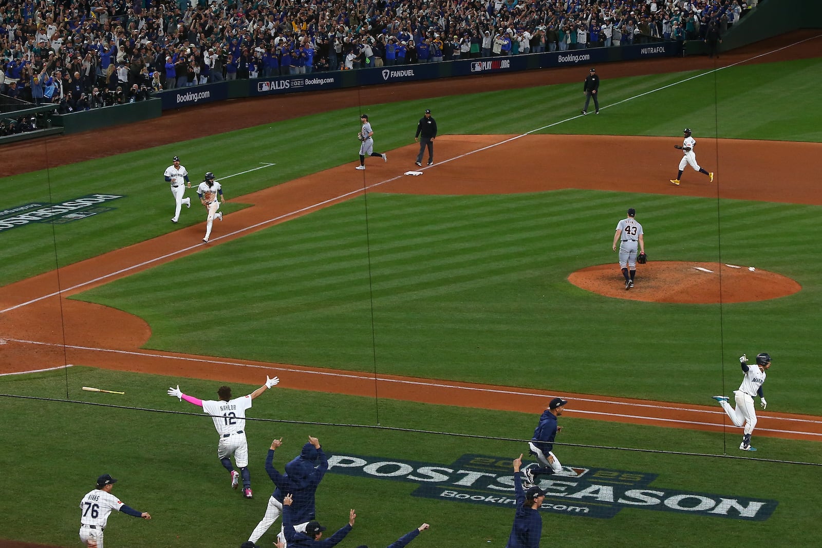 Players react after Seattle Mariners' Jorge Polanco, right, hit the game-winning RBI-single for J.P. Crawford to score during the 15th inning in Game 5 of baseball's American League Division Series against the Detroit Tigers, Friday, Oct. 10, 2025, in Seattle. (AP Photo/Lindsey Wasson)