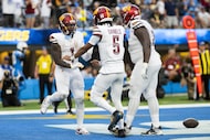 Washington Commanders wide receiver Deebo Samuel Sr. (1) quarterback Jayden Daniels (5) and...