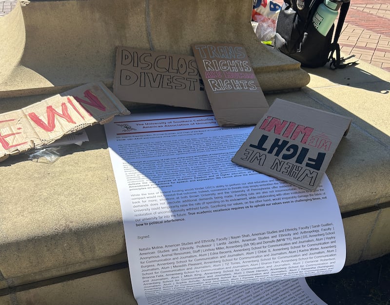 A large printed letter displayed on the grass near the Tommy Trojan stature, asking university administrators to reject Trump's academic compact.