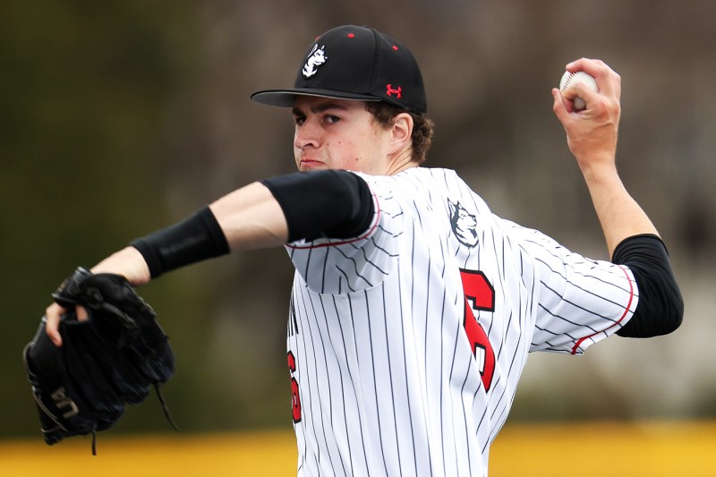 Cam Schlittler in his Northeastern jersey throwing a baseball.