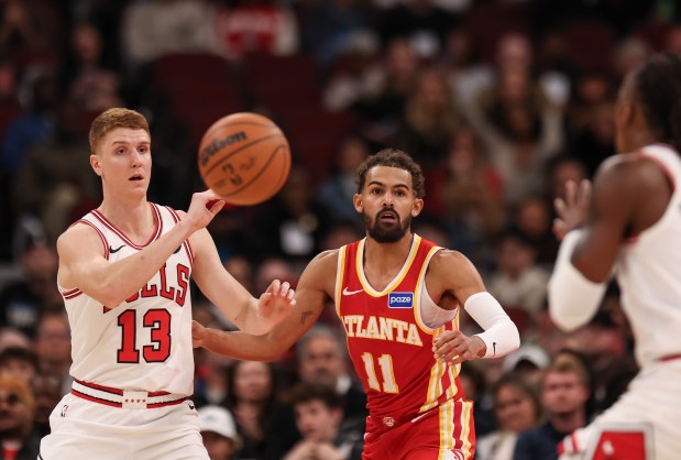 Chicago Bulls' Kevin Huerter (13) passes the ball to Chicago Bulls guard Ayo Dosunmu (11) in front of Atlanta Hawks guard Trae Young (11) in the fourth quarter during a game, Monday, Oct. 27, 2025, at the United Center in Chicago. (Dominic Di Palermo/Chicago Tribune)
