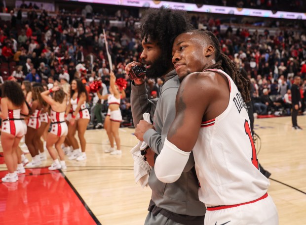 Chicago Bulls guard Ayo Dosunmu (11) hugs Chicago Bulls guard Coby White (0) after they won their game 128-123 against the Atlanta Hawks, Monday, Oct. 27, 2025, at the United Center in Chicago. (Dominic Di Palermo/Chicago Tribune)
