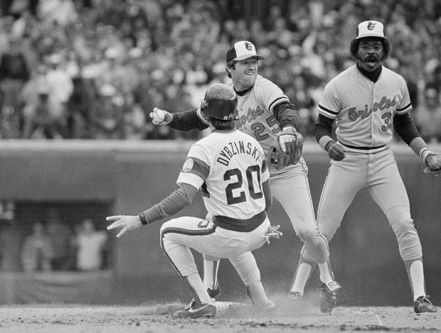During a rundown, Chicago White Sox player Jerry Dybzinski (20) stops short of second base as Baltimore Orioles second baseman Rich Dauer (25) fires for home plate to throw out Vance Law in the seventh inning of the American League playoffs, on Oct. 8, 1983, at Comiskey Park in Chicago. Eddie Murray backs up the play. (Rob Kozloff/AP)