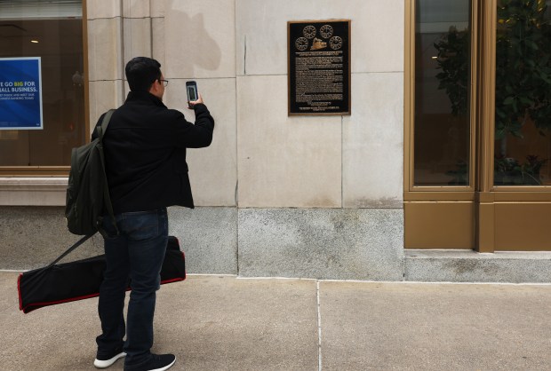 Quazi Hasan of Austin, Texas, takes a picture of a plaque commemorating the General Time Convention of 1883, where the Standard Time System was adopted, on a wall at the corner of South LaSalle Street and West Jackson Boulevard at the Central Standard Building, 231 S. LaSalle St., onNov. 1, 2023, in Chicago. (John J. Kim/Chicago Tribune)