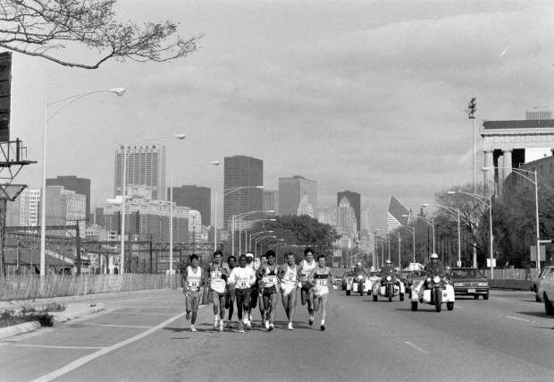 Alejandro Cruz (54) leads the field as the runners go past Soldier Field on South Lake Shore Drive during the Chicago Marathon on Oct. 30, 1988. (John Dziekan /Chicago Tribune)