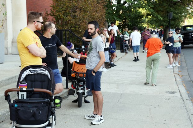 Community members line the perimeter of Funston Elementary School, 3616 W. Armitage Ave., near the end of the school day on Oct. 3, 2025. People in the community are on high alert for the possibility of action by federal immigration agents. (Terrence Antonio James/Chicago Tribune)