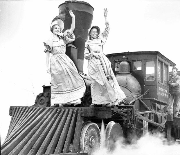 Norma Danielson, left, and Herta Reilly, in pre-Civil War costumes, get a ride on the Pioneer, a century-old locomotive, as it rolled under its own power during a preview of the Chicago Railroad Fair on July 14, 1948. (Chicago Tribune historical photo)