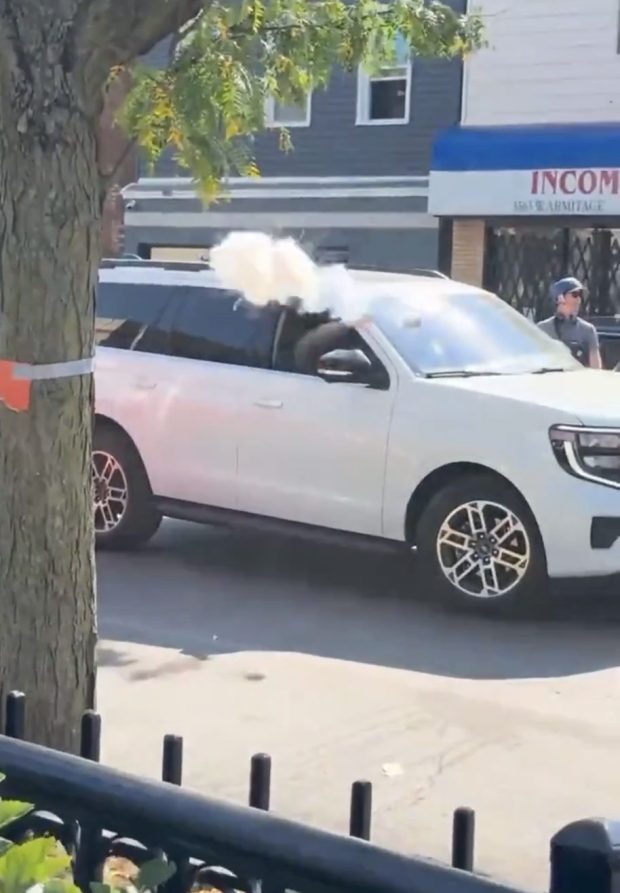 An image taken from a video shows a federal immigration agent throwing a gas canister into the street near Rico Fresh Market in the 3500 block of West Armitage Avenue in Chicago on Oct. 3, 2025 (Andrew Denton)