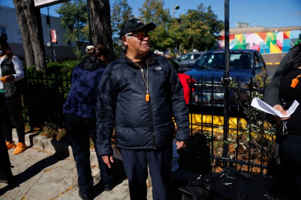 Rueben Antonio Cruz talks with people from the neighborhood after being ticketed by Immigration and Customs Enforcement officers for not having his permanent resident paperwork with him, Oct. 9, 2025, near the intersection of North Clark Street and West Lunt Avenue in the Rogers Park neighborhood. (Armando L. Sanchez/Chicago Tribune)
