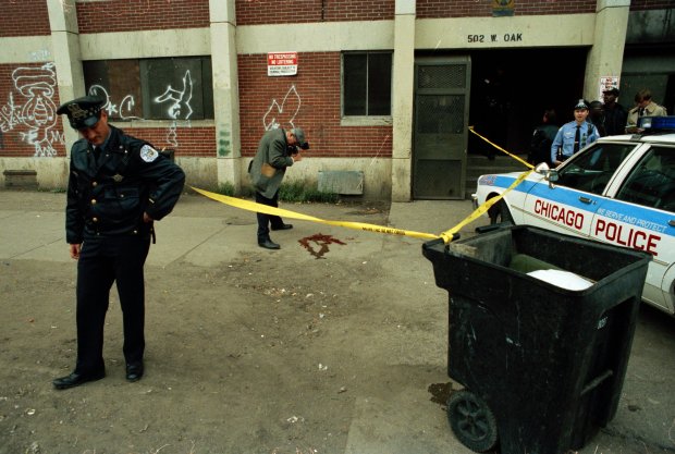 A Chicago police officer guards the scene as an investigator photographs the blood left after the shooting of Dantrell Davis at 502 W. Oak St. on Oct. 13, 1992, in Chicago. (Eduardo Contreras/Chicago Tribune)
