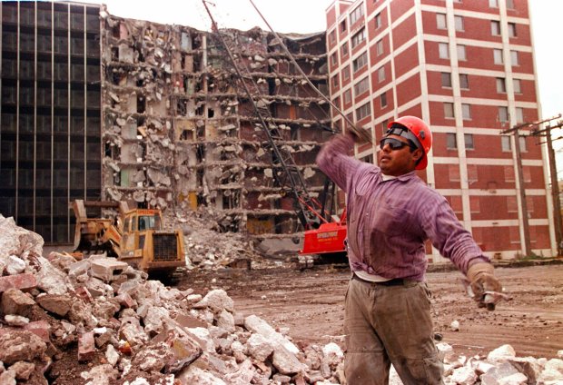 Greg Hernandez separates materials from a pile of rubble during the teardown of the Cabrini-Green projects at 1157 and 1159 Cleveland Ave. on Oct. 30, 1995, in Chicago. (José Moré/Chicago Tribune)