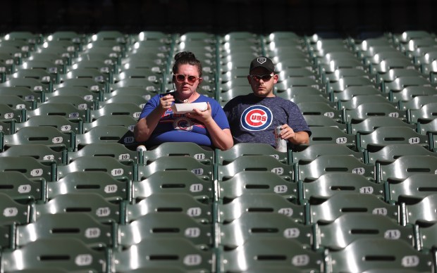 Two Chicago Cubs fans relax in their seats before the start of the NL Division Series Game 1 against the Milwaukee Brewers at American Family Field in Milwaukee on Oct. 4, 2025. (Chris Sweda/Chicago Tribune)