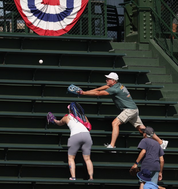 Fans try to catch a ball in the left field bleachers during batting practice ahead of Game 3 of the wild-card series between the Cubs and the Padres at Wrigley Field on Oct. 2, 2025. (Chris Sweda/Chicago Tribune)