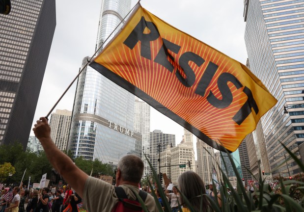 A demonstrator holds a flag that reads, "Resist," as fellow demonstrators march on Wacker Drive during the "No Kings" march after a rally at Butler Field Saturday, Oct. 18, 2025, in Chicago. (John J. Kim/Chicago Tribune)