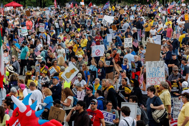 People gather while attending a No Kings rally in Grant Park in response to President Donald Trump's increased immigration enforcement actions in the area Saturday Oct. 18, 2025. (Armando L. Sanchez/Chicago Tribune)