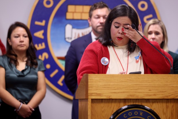 Wiping away a tear, Vanessa Aguirre-Ávalos, sho had witnessed an ICE incident outside her business, speaks as alderpersons, elected officials and residents who had witnessed Immigration and Customs Enforcement agents activity during a press conference at City Hall, Oct. 31, 2025. (Antonio Perez/Chicago Tribune)