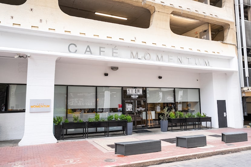 Front exterior of a restaurant, white building with standing flower beds in front