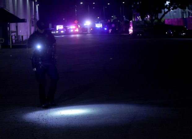 An Alameda police officer looks for shell casings after shots were fired near the Coast Guard Island entrance in Oakland, Calif. on Thursday, Oct. 23, 2025. U.S. Coast Guard police opened fire on a U-Haul truck after it backed up a ramp at the entrance to the Alameda island, where U.S. Customs and Border Patrol agents have been staying. (Jane Tyska/Bay Area News Group)
