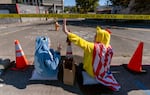 Protesters wave to passersby as they wait outside of the U.S. Immigration and Customs Enforcement building in South Portland, where U.S. Department of Homeland Security Secretary Kristi Noem is visiting, Oct. 7, 2025.