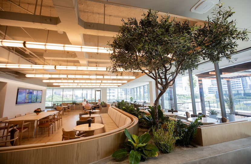 People work and chat in the RISE Café seating area at CBRE’s global headquarters in Dallas...