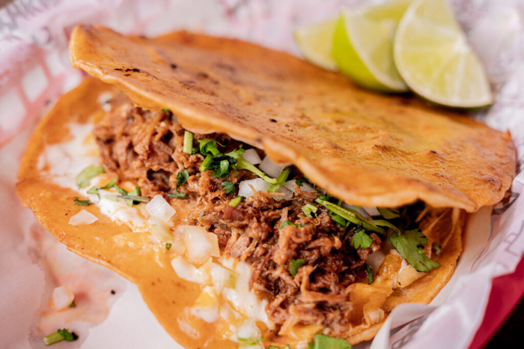 Image shows a taco stuffed with beef on a plate.