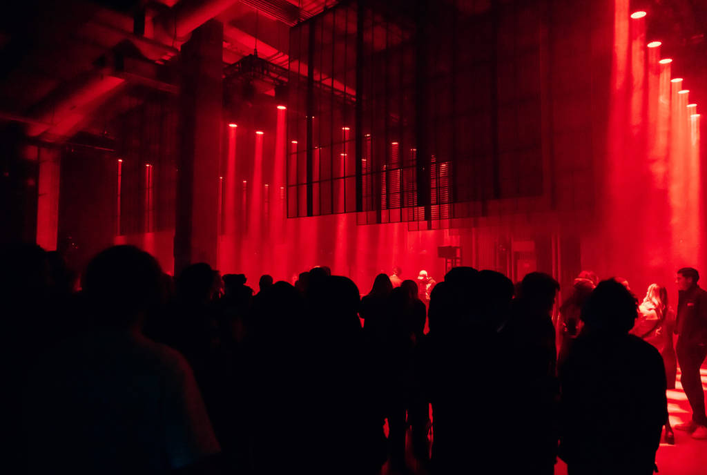 Image shows Art Club at POST in Houston with club-goers hanging out in moody lights.