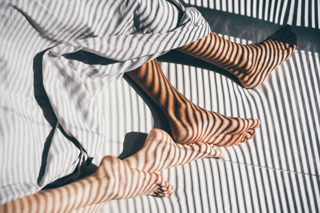 Interracial couple sleeping on the bed. Close up legs.