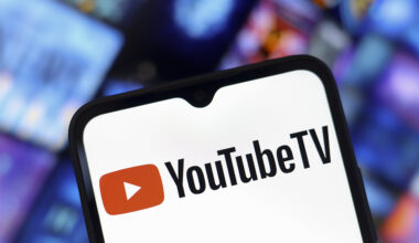 The YouTube TV logo appears on the screen of a smartphone and in the background on the computer screen in Reno, United States, on December 15, 2024.