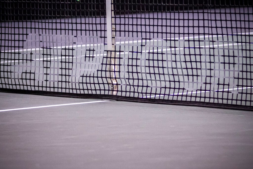 The ATP TOUR logo inscription in the net of the tennis court.