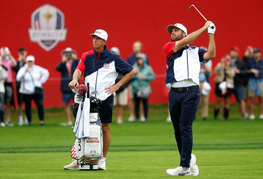Scottie Scheffler of Team United States plays a shot on the 15th hole while his caddie Ted Scott looks on during a practice round prior to the Ryder Cup 2025 at Black Course at Bethpage State Park Golf Course on September 25, 2025 in Farmingdale, New York.