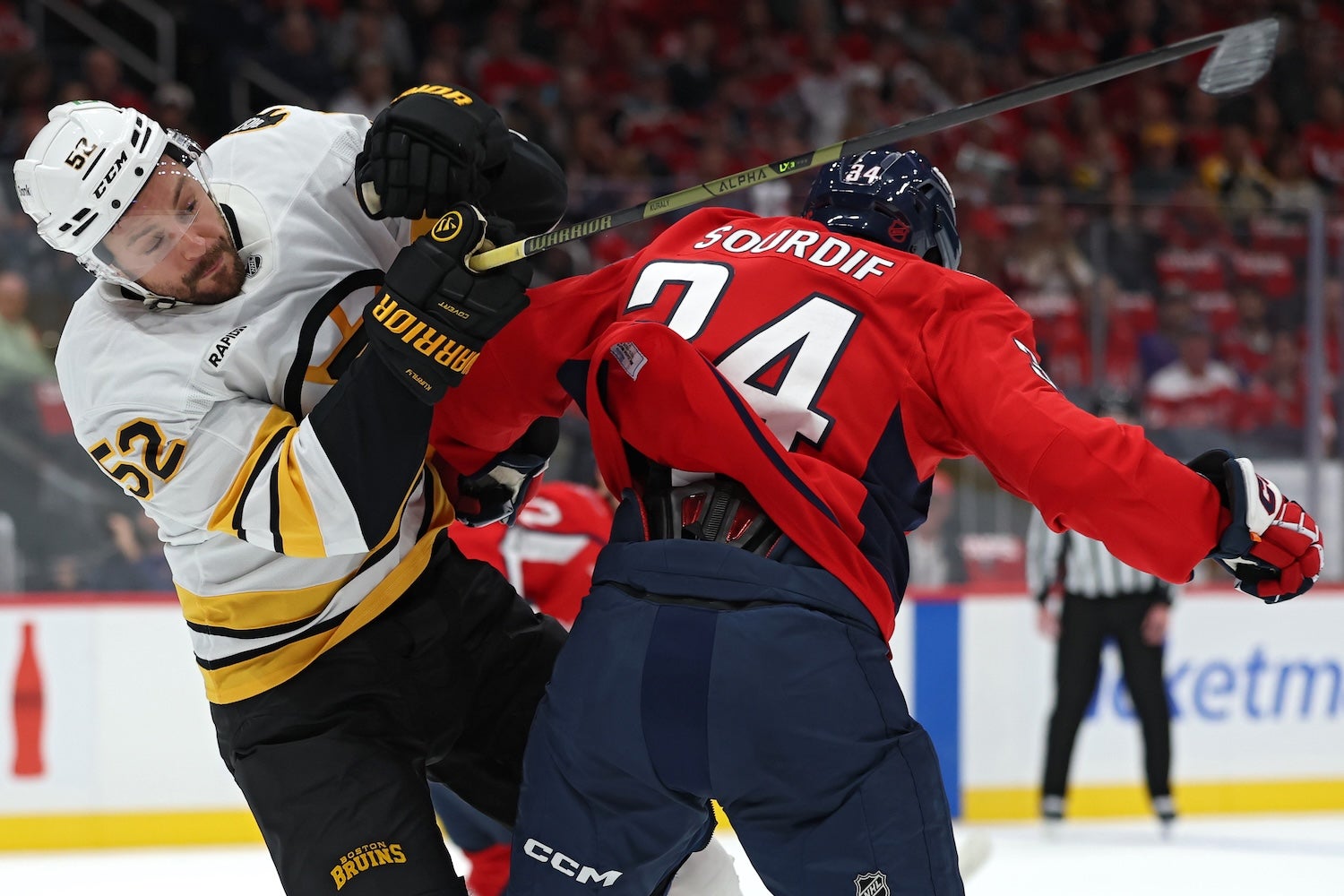 WASHINGTON, DC - OCTOBER 08: Sean Kuraly #52 of the Boston Bruins checks Justin Sourdif #34 of the Washington Capitals during the first period at Capital One Arena on October 8, 2025 in Washington, DC. (Photo by Patrick Smith/Getty Images)