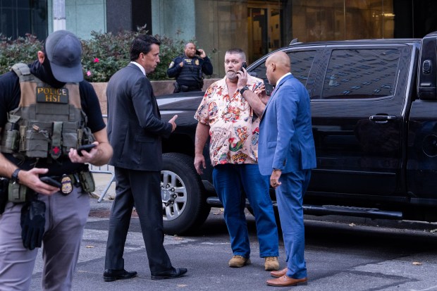 William Joyce, New York City acting field office director at the Department of Homeland Security, (center) speaks on the phone as federal agents and law enforcement stand outside of 26 Federal Plaza on October 21, 2025 in New York City. (Photo by Adam Gray/Getty Images)