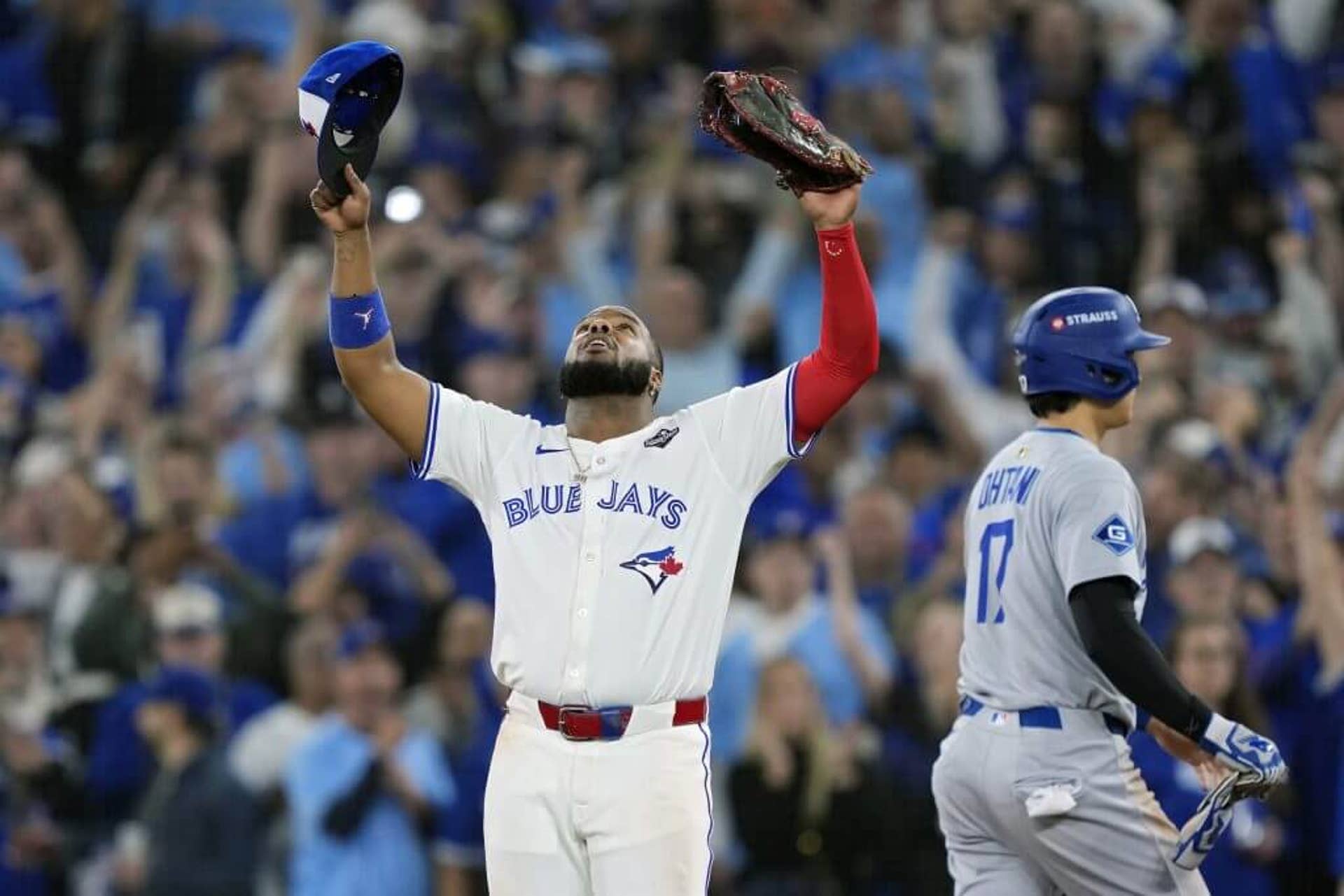Blue Jays' Vladimir Guerrero Jr. celebrates as Dodgers' Shohei Ohtani walks off the field after Toronto takes Game 1 of the World Series.