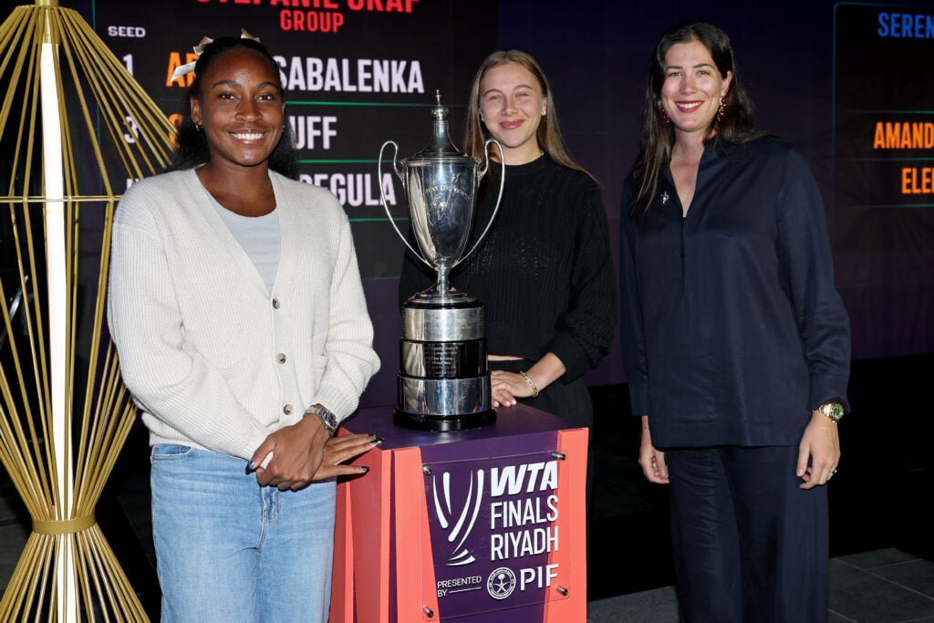 Coco Gauff and Amanda Anisimova pose next to the WTA Finals trophy in 2025