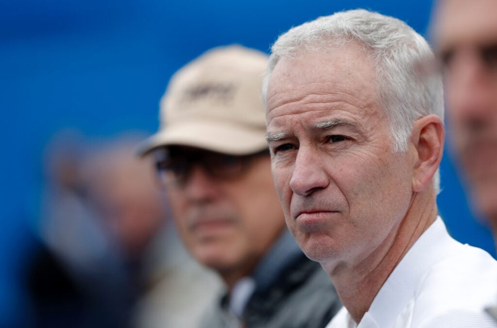 John McEnroe watches as Australia's Bernard Tomic returns to Canada's Milos Raonic during their men's singles semi-final match in the ATP Aegon Championships tennis tournament at the Queen's Club in west London.