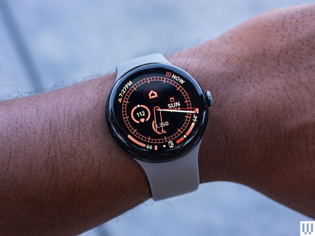 Person's wrist wearing a Google Pixel Watch 3, a smartwatch with the screen showing time, date, and health metrics such as heart rate and number of steps walked