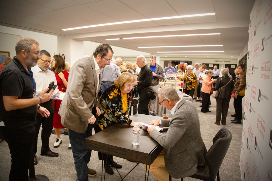 An author signing books in front of a long line.