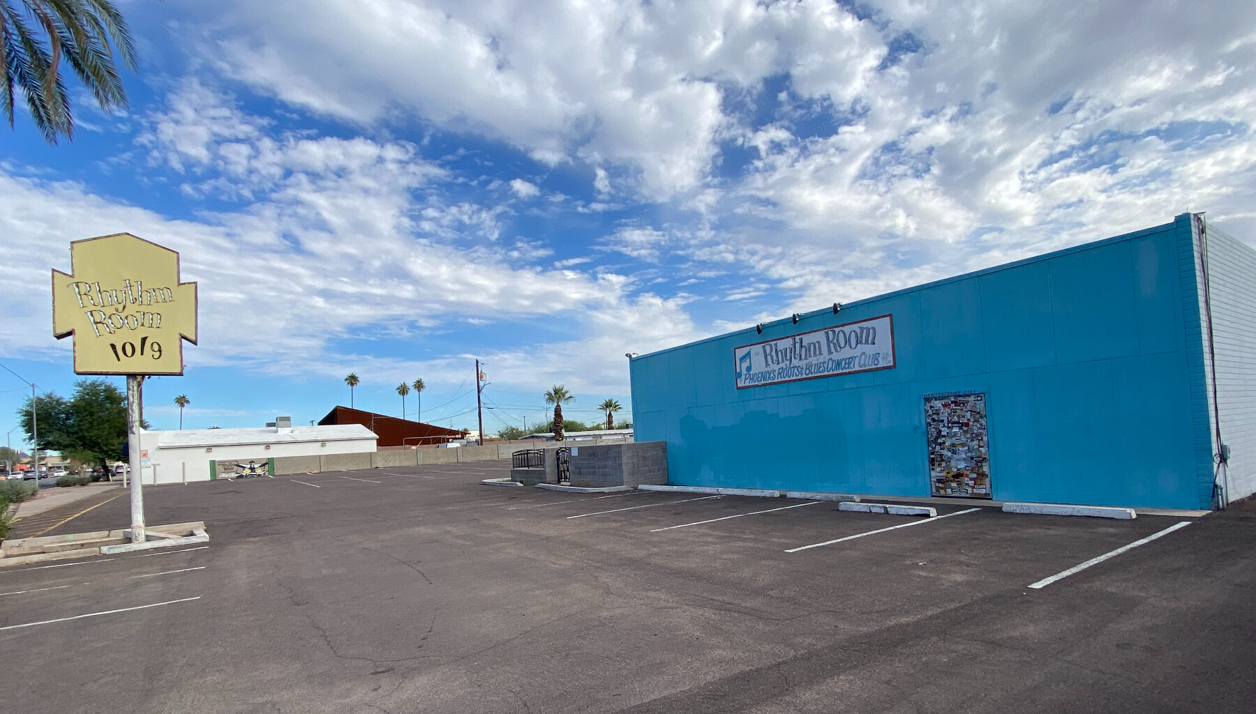The parking lot and exterior of a squat blues club.