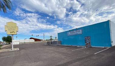 The parking lot and exterior of a squat blues club.