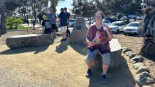 Wendy Adelstein, holds a bouquet of flowers and a cup of mocha, Saturday, honoring her late friend, Steven Krueger, Ocean Beach, Calif., October 11, 2025.