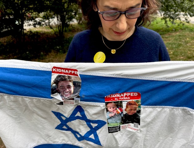 Dr. Rebecca Mannis, 61, holds an Israeli flag near the gathering in Central Park on Sunday. 