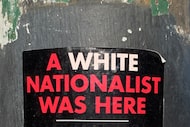 A white-nationalist sticker affixed to a traffic-light pole at Harwood and Jackson streets...