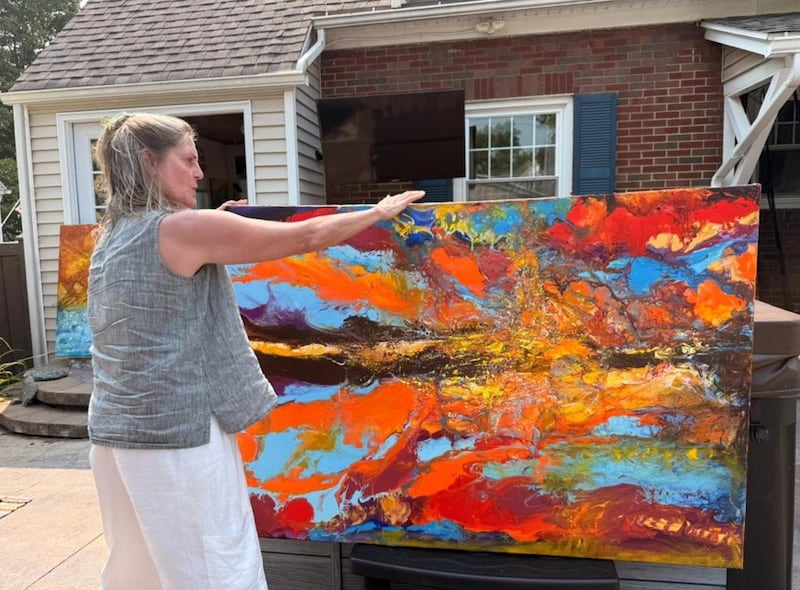 JoAnne Sharman shows one of her pouring acrylic paintings in her house in Auburn, New York, on Monday, August 4, 2025. Sharman became a full-time artist in December 2024 after retirement. (Photo by Zora Ma)