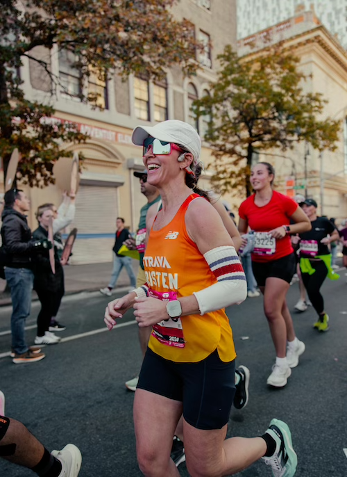 Outside Gear & Affiliate Director Kristen Geil running the 2024 NYC Marathon using a pair of socks as arm warmers