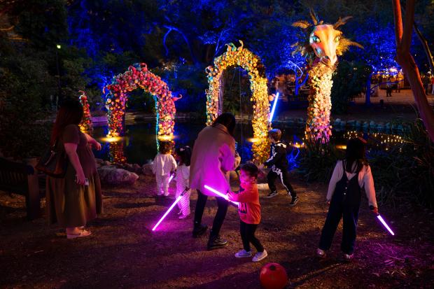 Children play in font of a pumpkin serpent at “Carved”...