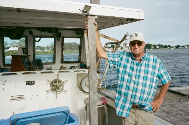 Gary Whetmore stands for a portrait on his boat in Norwalk on Aug. 19, 2025. Credit: Dana Edwards / CT Mirror
