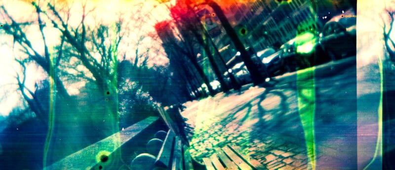 A sunlit park path with benches and leafless trees is overlaid with colorful light leaks and distorted effects, creating a dreamy, abstract atmosphere.
