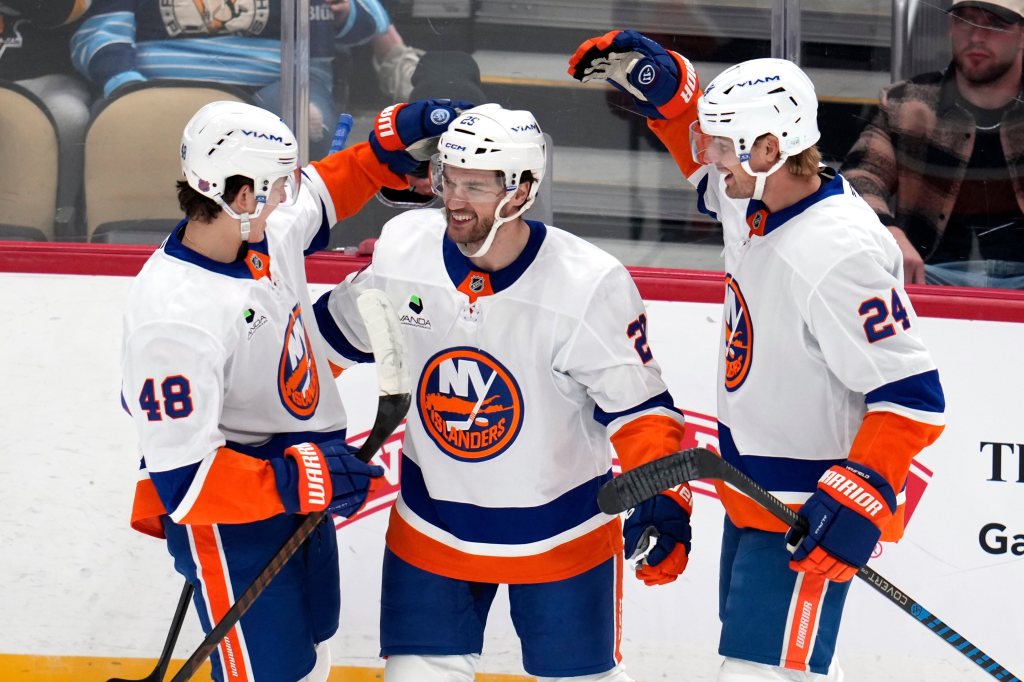 Matthew Schaefer (left) picked up his first NHL point when he assisted on a goal by Jonathan Drouin (center) as Scott Mayfield (right) celebrates with them both during the Islanders' opening night game against the Penguins in Pittsburgh on Oct. 9, 2025.