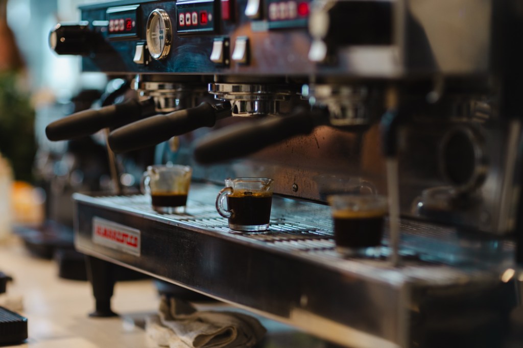 Three shots of espresso sitting on an espresso machine