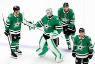 Dallas Stars goaltender Casey Desmith (1) gets a fist bump from teammate Justin Hryckowian...